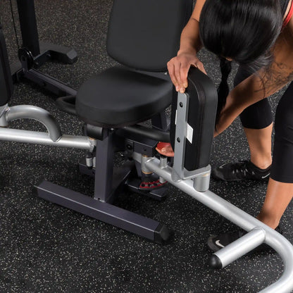 Woman adjusting black weight bench in gym.