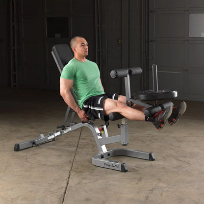 Man using Body-Solid leg extension machine in green shirt, focusing on leg workout.
