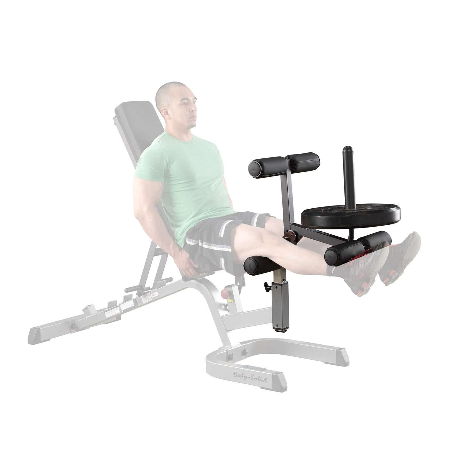 Body-Solid leg extension attachment with weight plates, designed for strength training on a home gym bench.