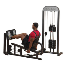 Man using Body-Solid leg press machine in gym, wearing red shirt.