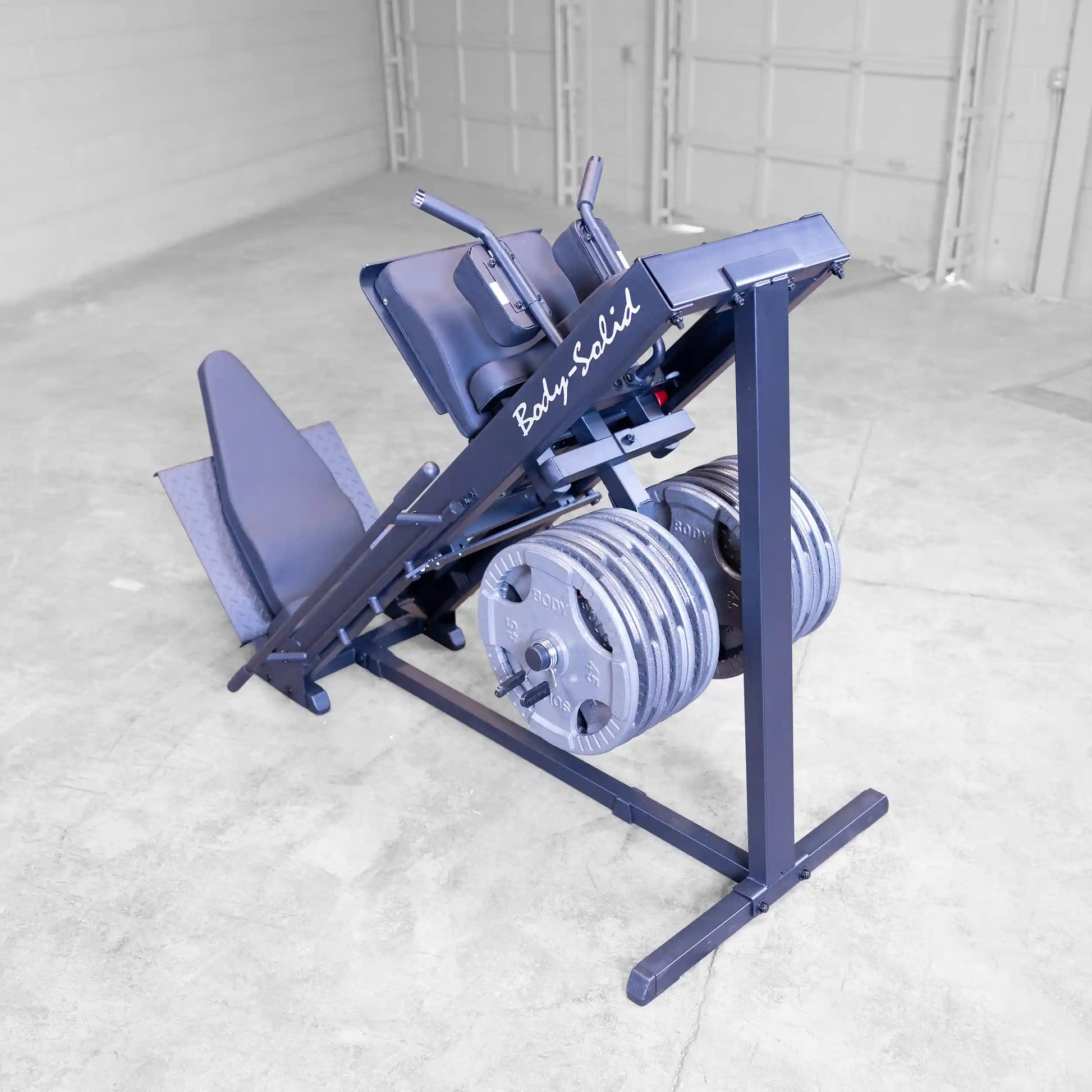Body-Solid leg press machine with weight plates in a gym setting.