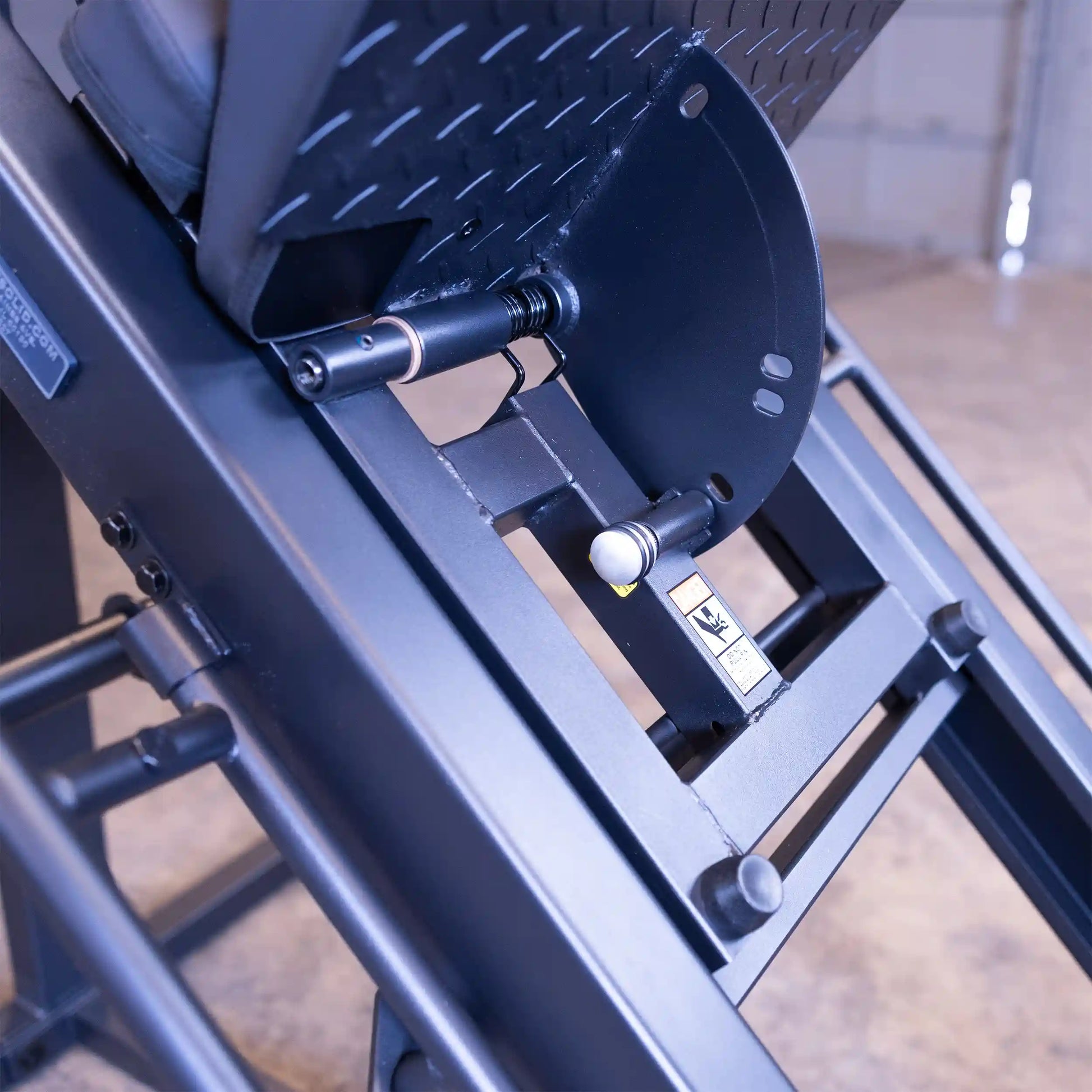 Leg press machine with adjustable steel frame and safety lock mechanism.