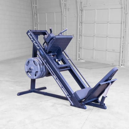 Body-Solid leg press machine with multiple weight plates in a spacious gym.