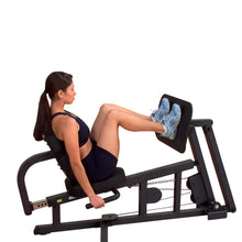 Woman using a leg press machine in a gym, wearing blue sneakers.
