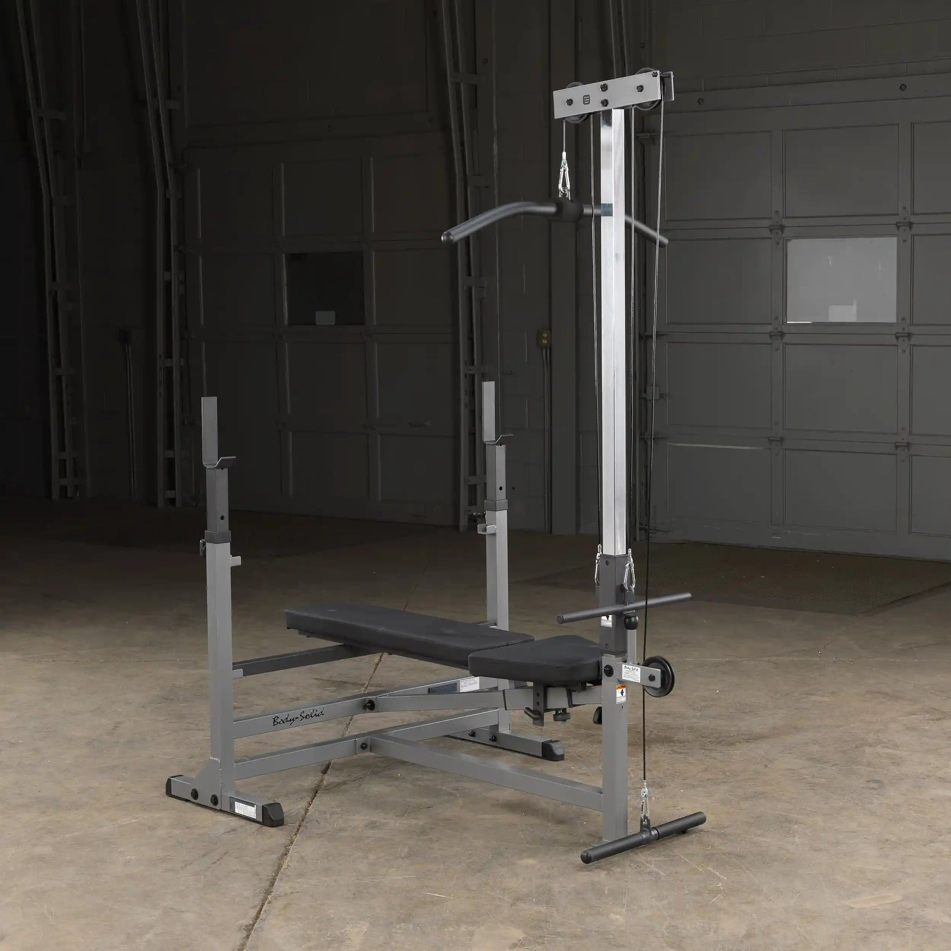 Body-Solid weight bench with lat pulldown in a garage gym setting.