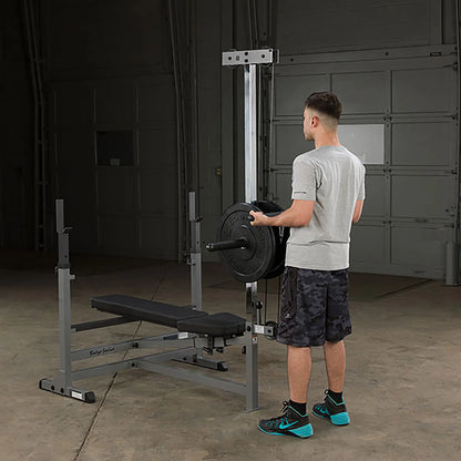 Man loading weights on Body-Solid workout bench in garage gym.