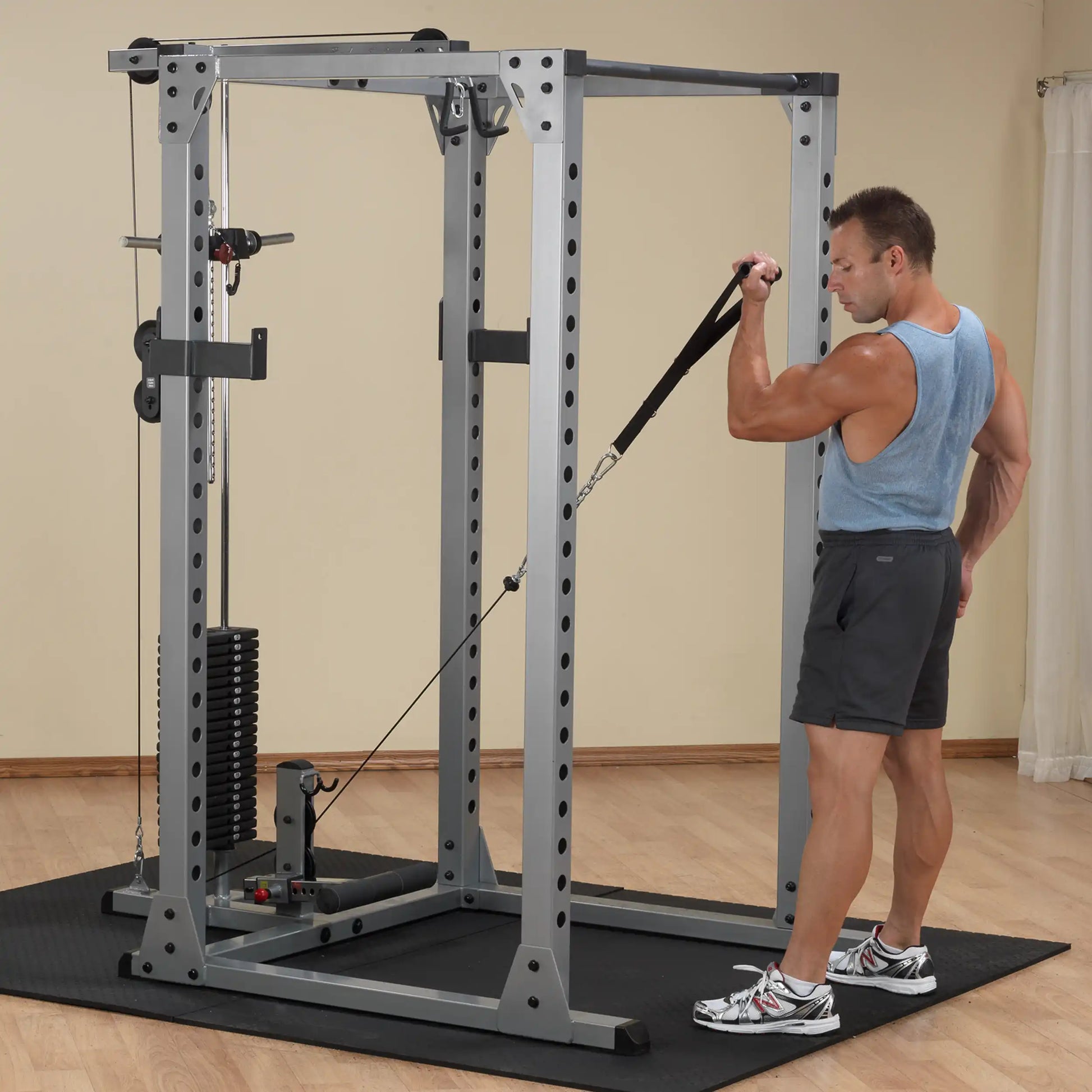 Man using a cable machine for bicep curls in a home gym.
