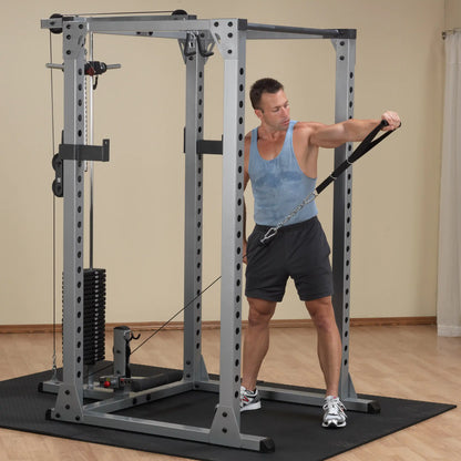 Man using cable machine for arm workout in home gym.