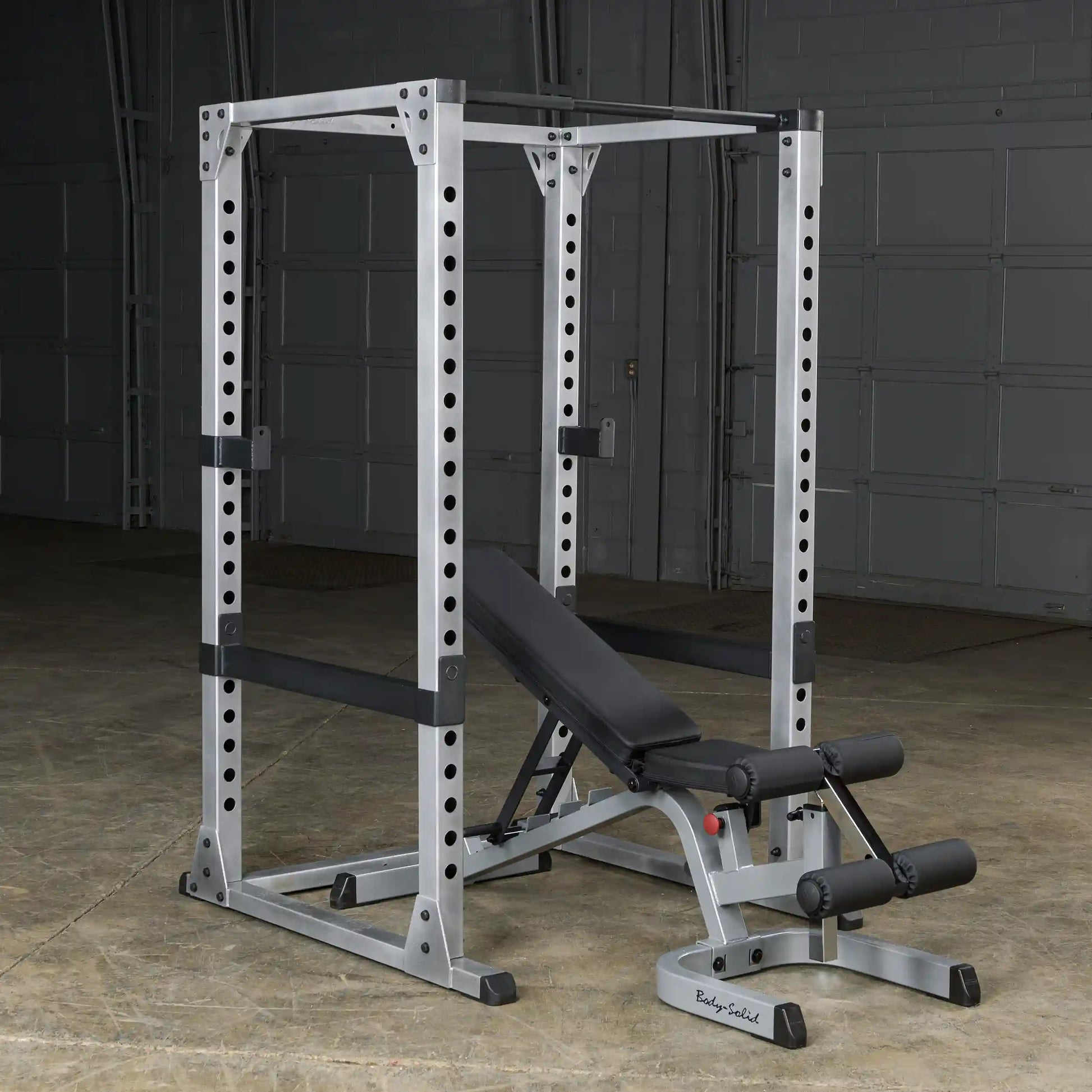 Body-Solid power rack with adjustable bench in a grey garage gym.