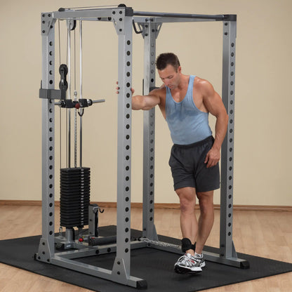 Man using Powerline PFT100 cable machine in home gym.