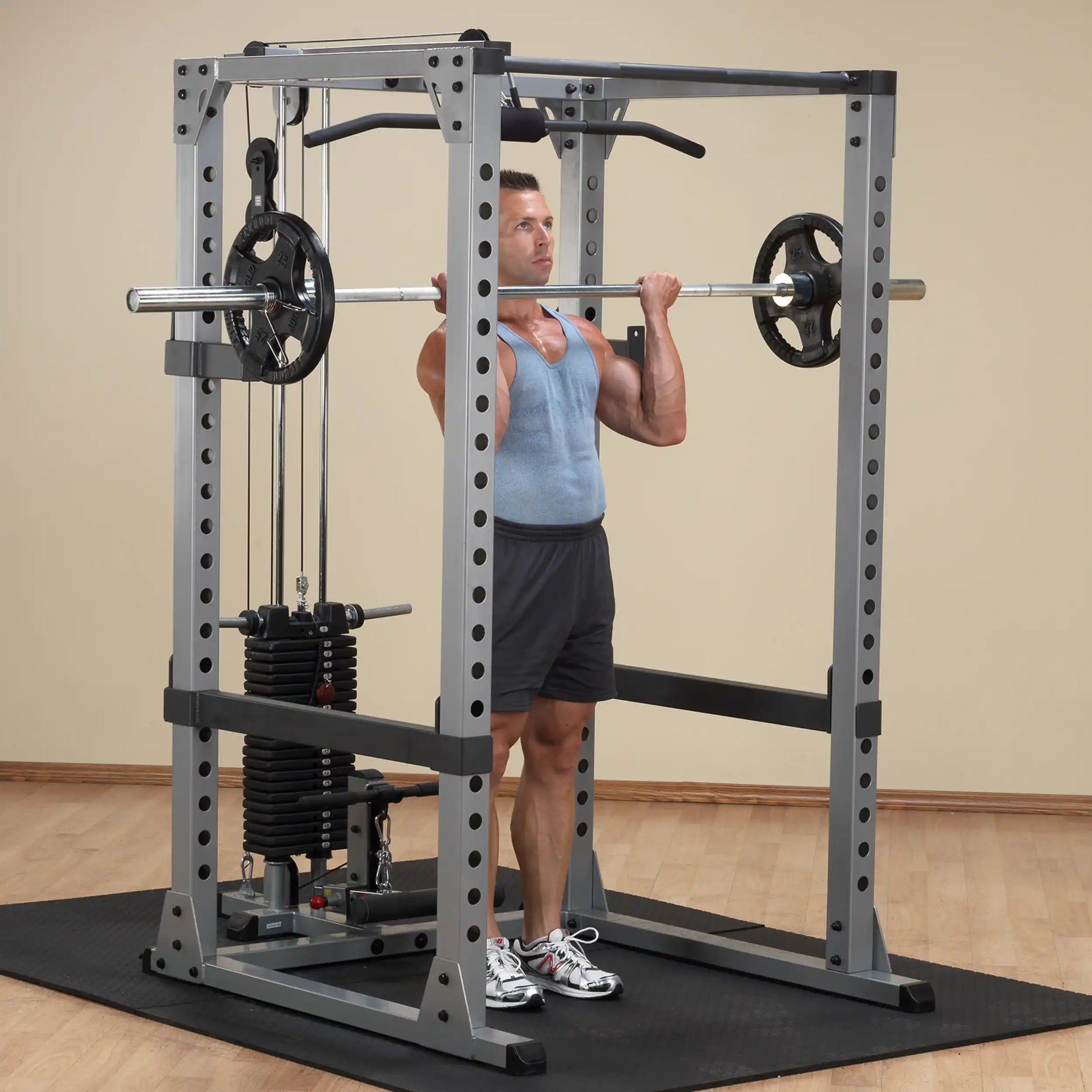 Man lifting weights in a silver Smith machine with stack weights in a gym setting.