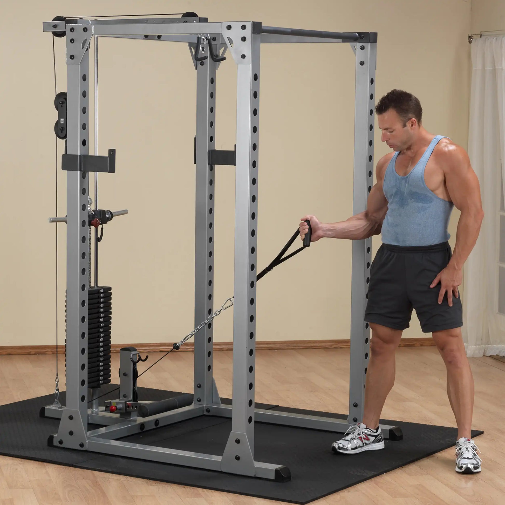 Man using a power rack with cable attachment in a home gym.