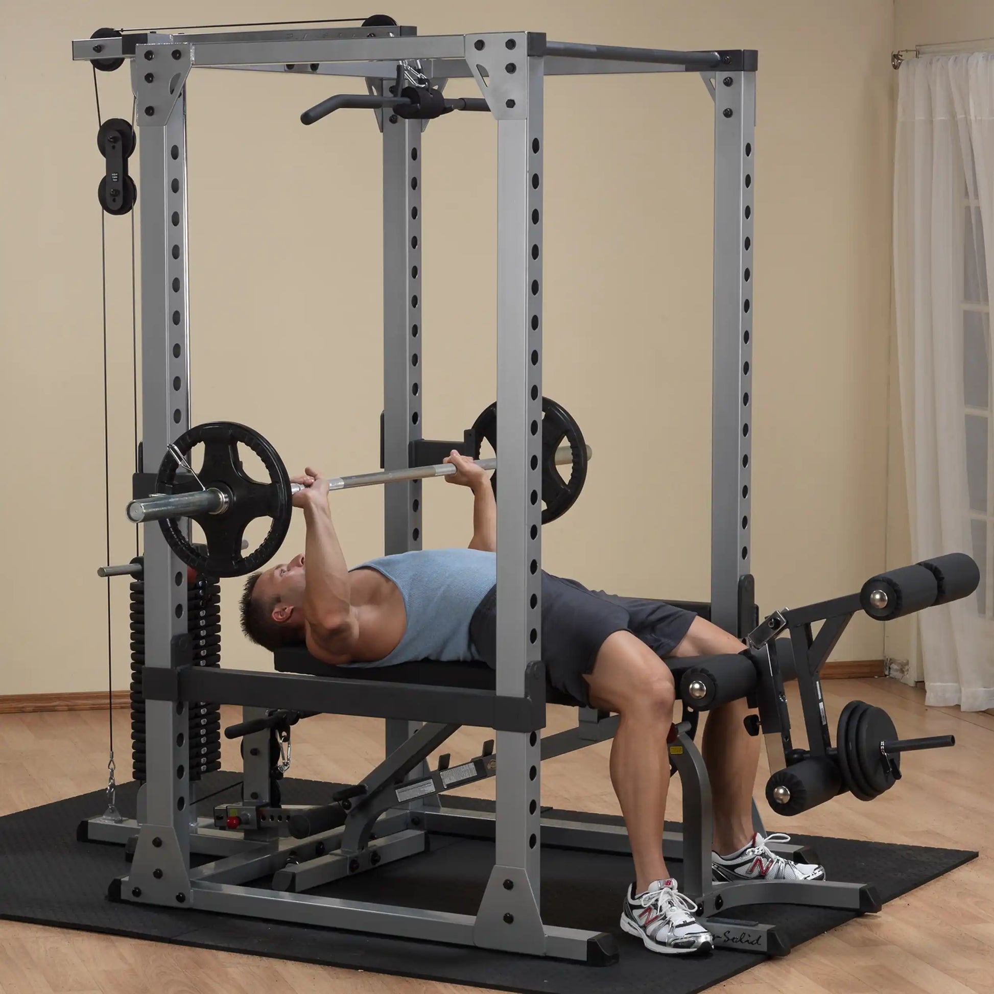 Man bench pressing on Powerline gym equipment in home setting.