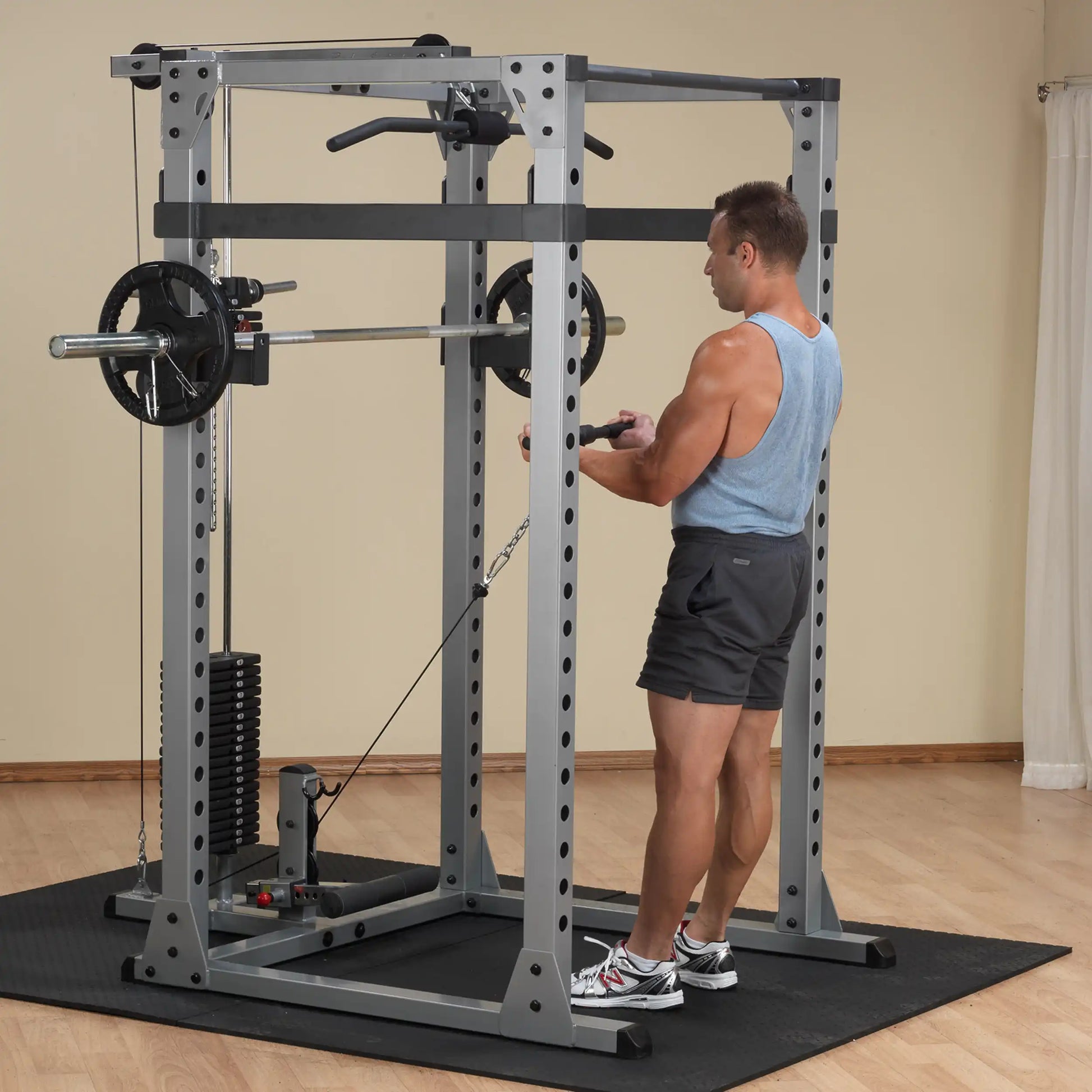 Man using a cable machine in a home gym, performing a tricep exercise.