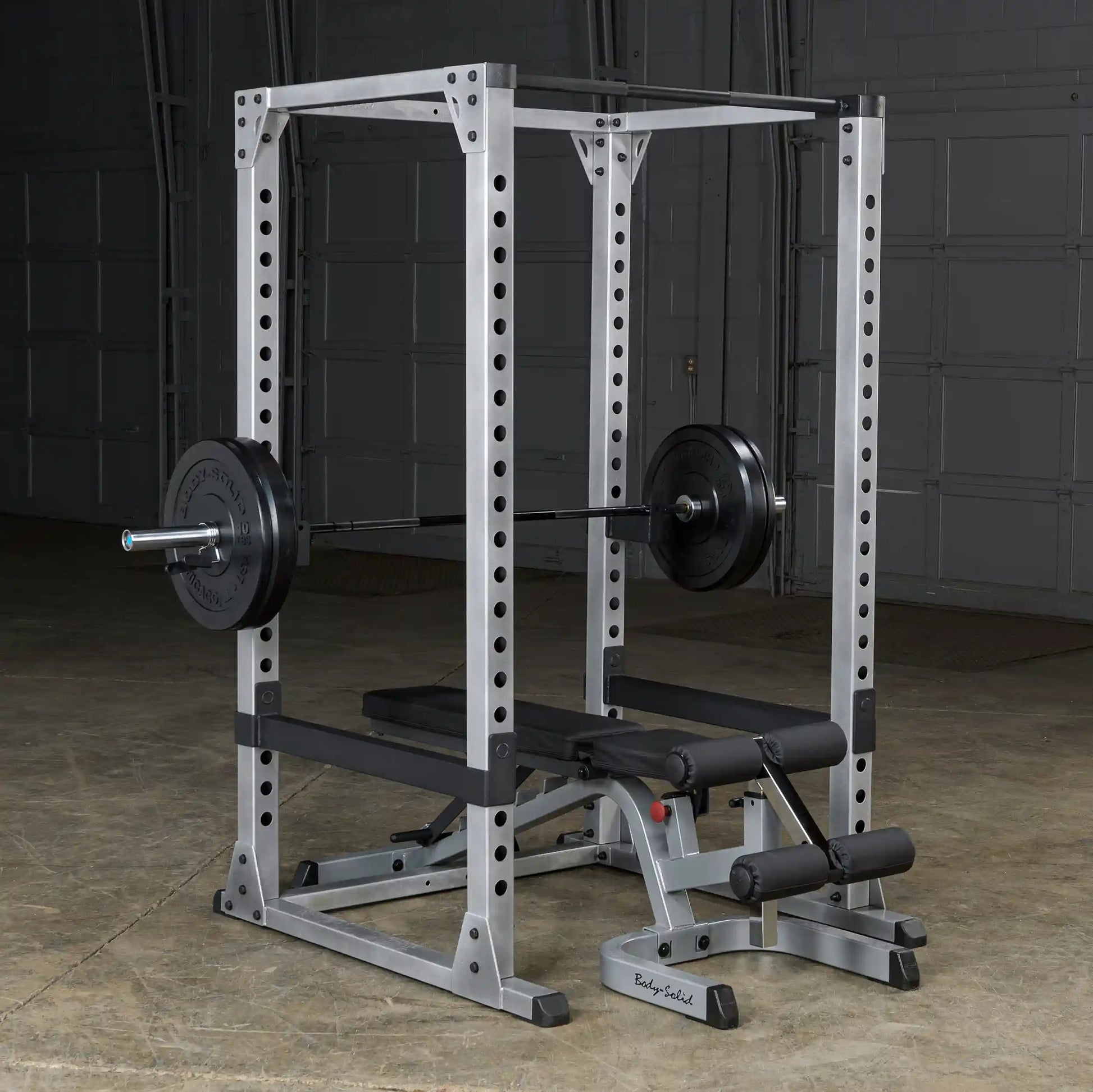 Body-Solid power rack with adjustable bench and loaded barbell in a gym setting.