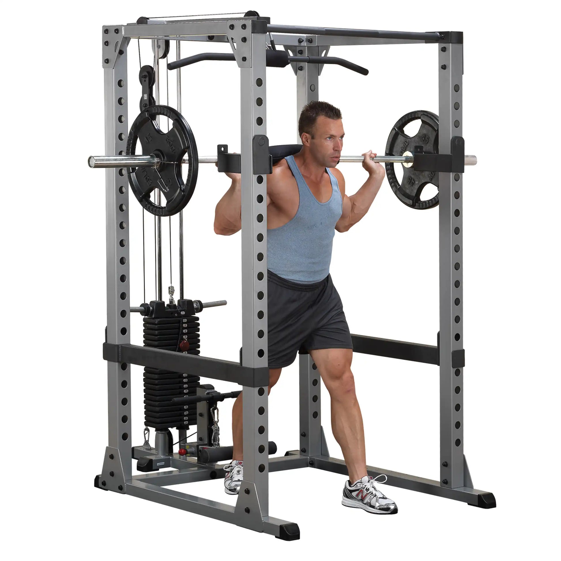 Man using a Smith machine for squats, wearing a blue tank top and black shorts.