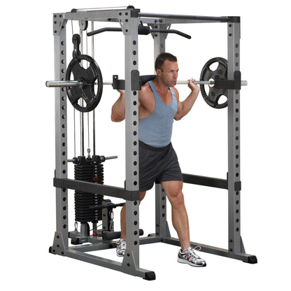 Man using a Smith machine for squats, wearing a blue tank top and black shorts.