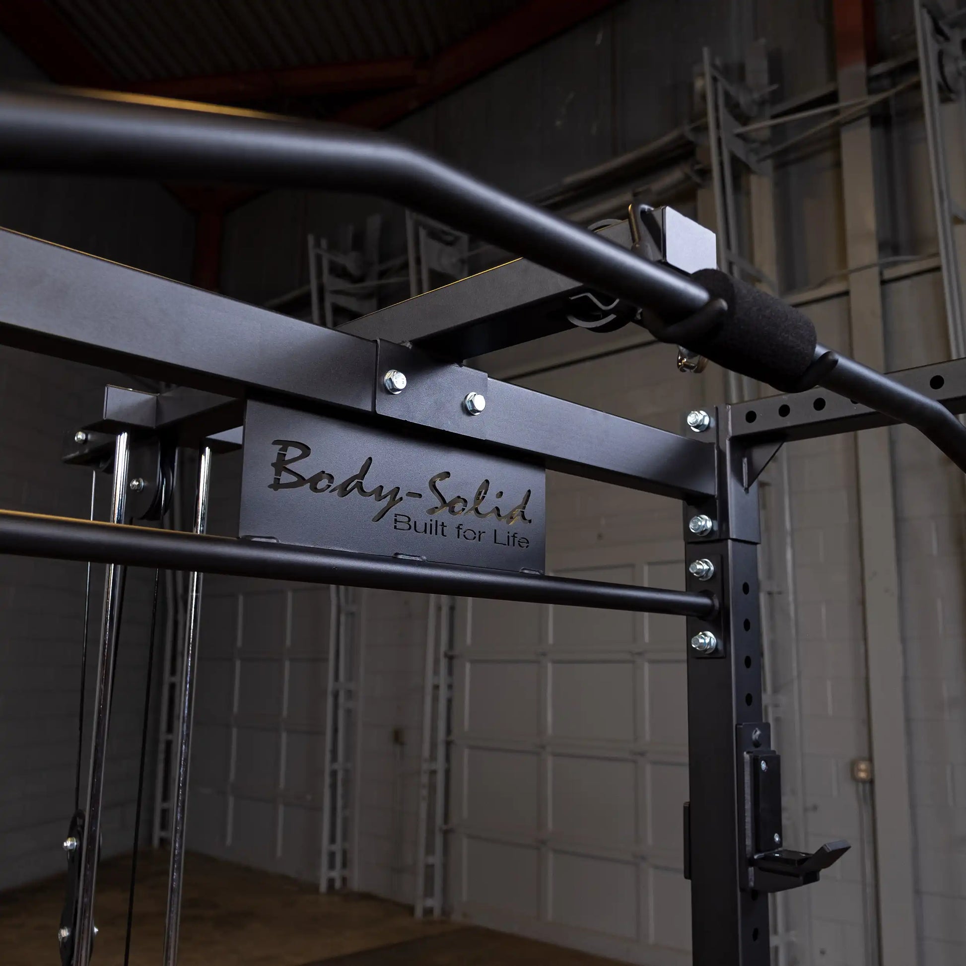Body-Solid power rack with black steel frame in a gym setting.