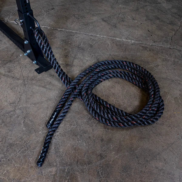 Battle rope attached to a metal frame on a concrete gym floor, ideal for strength training.