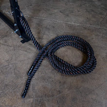 Battle rope attached to a metal frame on a concrete gym floor, ideal for strength training.