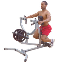 Man using Body-Solid T-Bar Row Machine for strength training in red shorts.