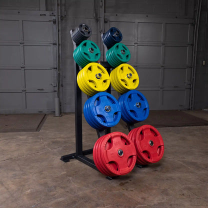 Colorful weight plates on storage rack in gym setting.