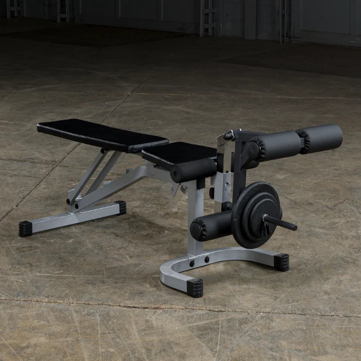A weight bench with adjustable backrest and attached leg extension, set against a concrete floor background.