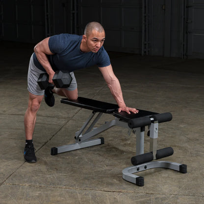 A man performing a single-arm dumbbell row exercise on a workout bench, showcasing his muscular build and focus.