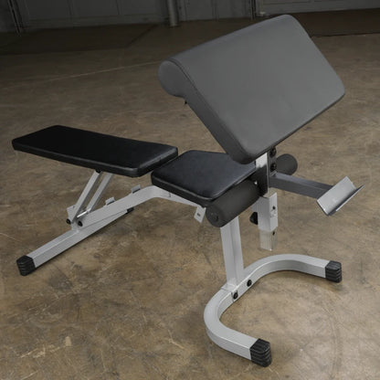 A black and silver adjustable workout bench positioned on a concrete floor, designed for strength training exercises.