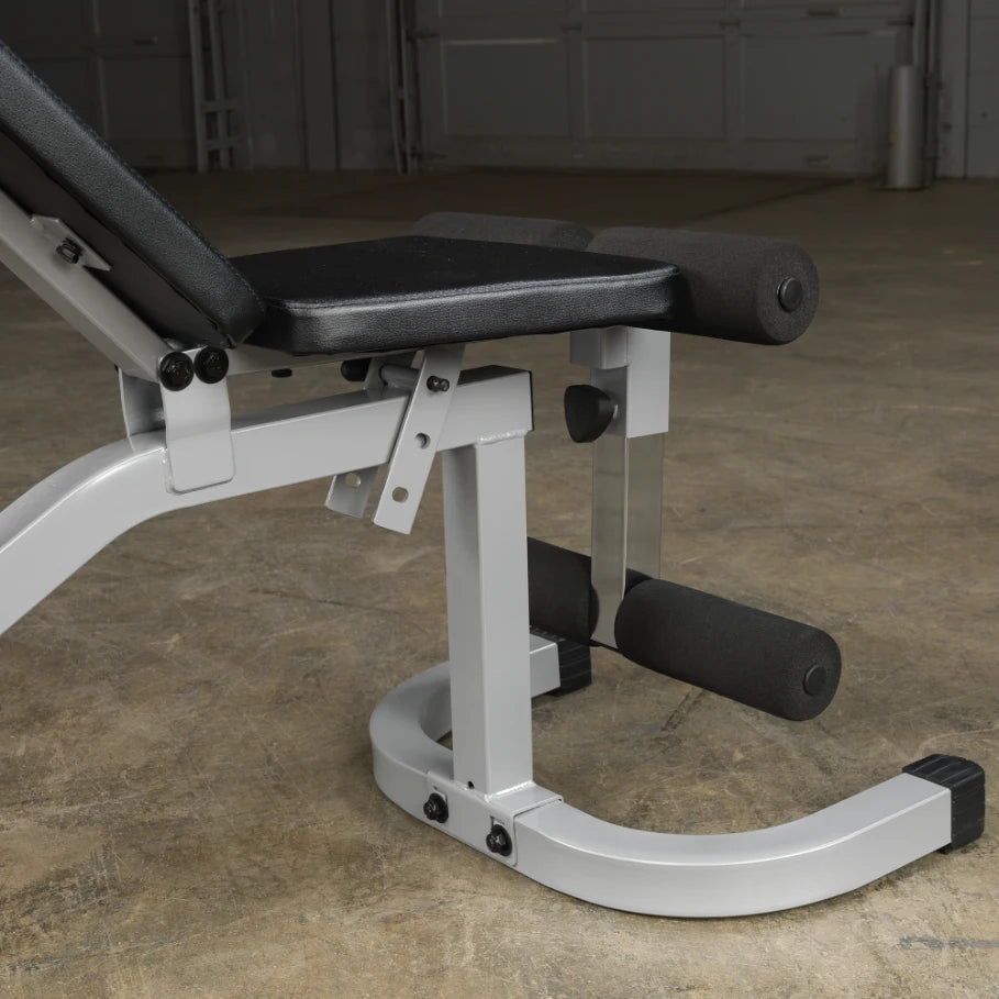 Close-up view of a weight bench with adjustable backrest, featuring padded supports and a sturdy metal frame, set against a concrete floor.