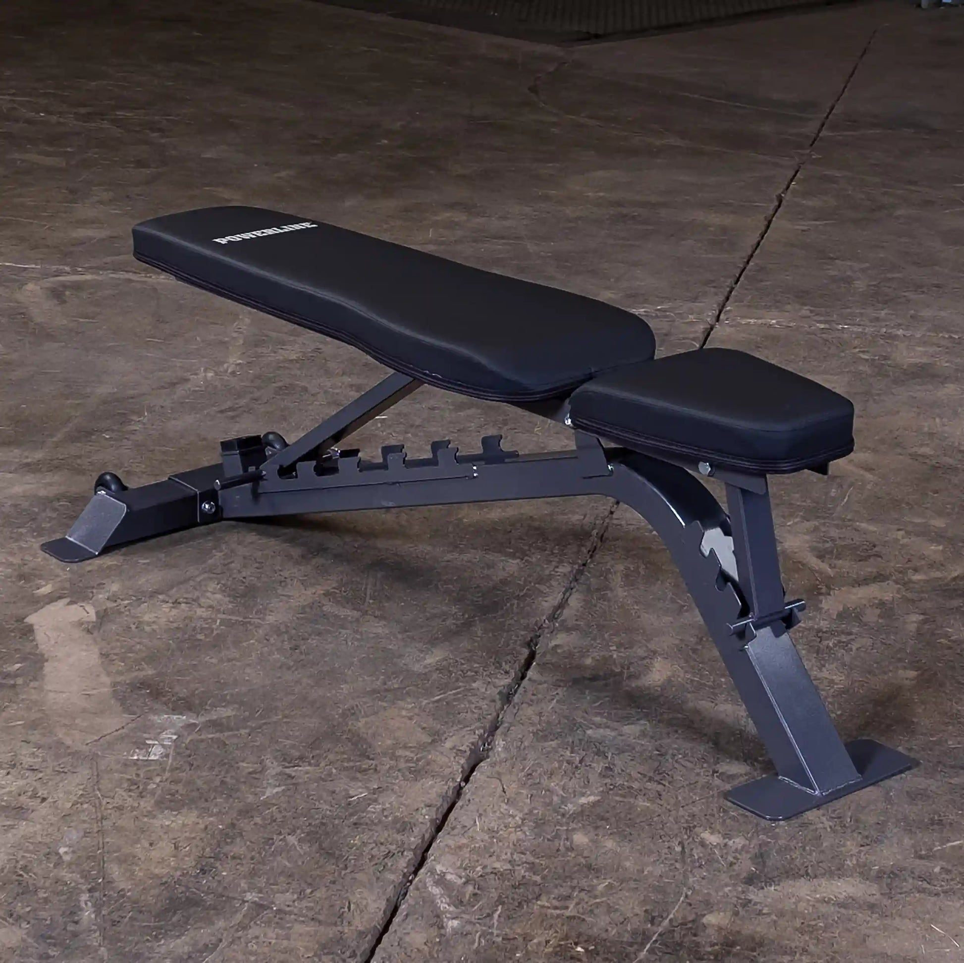 Adjustable weight bench with a padded seat and backrest, set on a concrete floor.