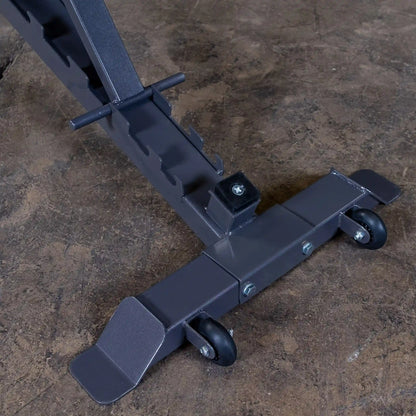 Close-up view of a gray metal support frame with wheels and adjustable features, resting on a textured concrete surface.