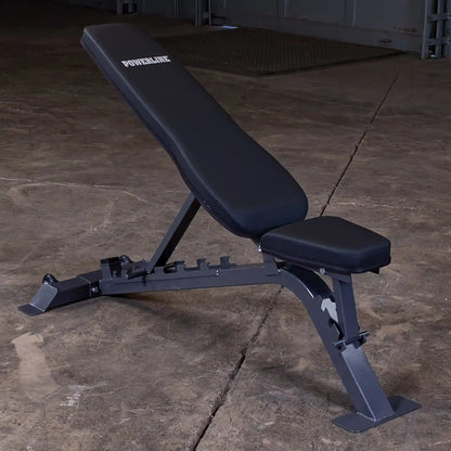 A black adjustable weight bench with the brand name POWERLINE displayed on the backrest, set against a concrete floor background.