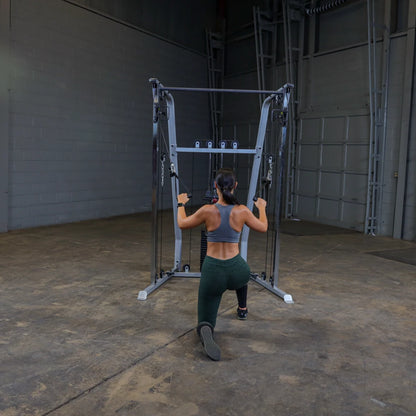 A person performing a lunge exercise using a cable machine in a gym setting, wearing a sports bra and leggings, with a focus on strength training.