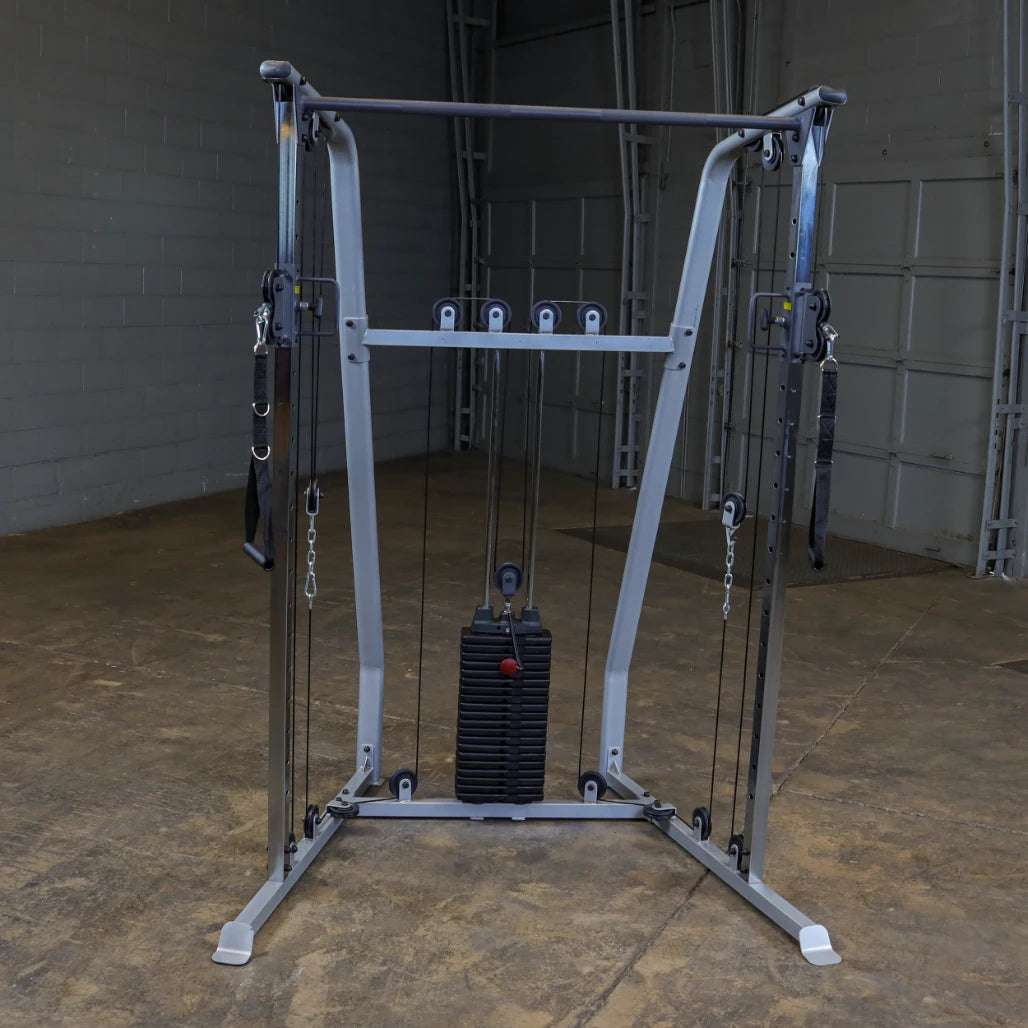 A multi-functional cable machine for strength training, featuring adjustable pulleys and a weight stack, set in a gym environment with a concrete floor and gray walls.