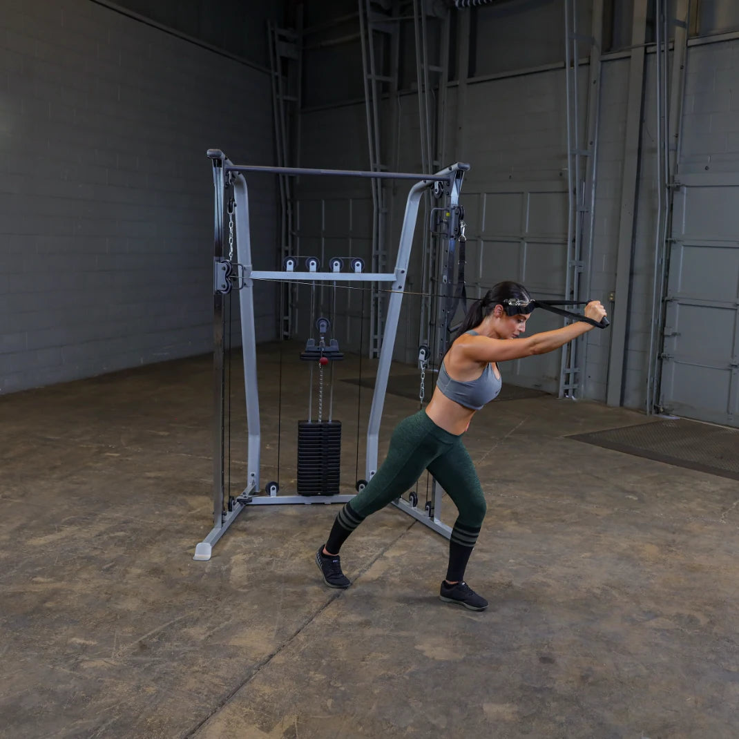 A woman in athletic wear performs a cable exercise in a gym, demonstrating strength training with a cable machine.
