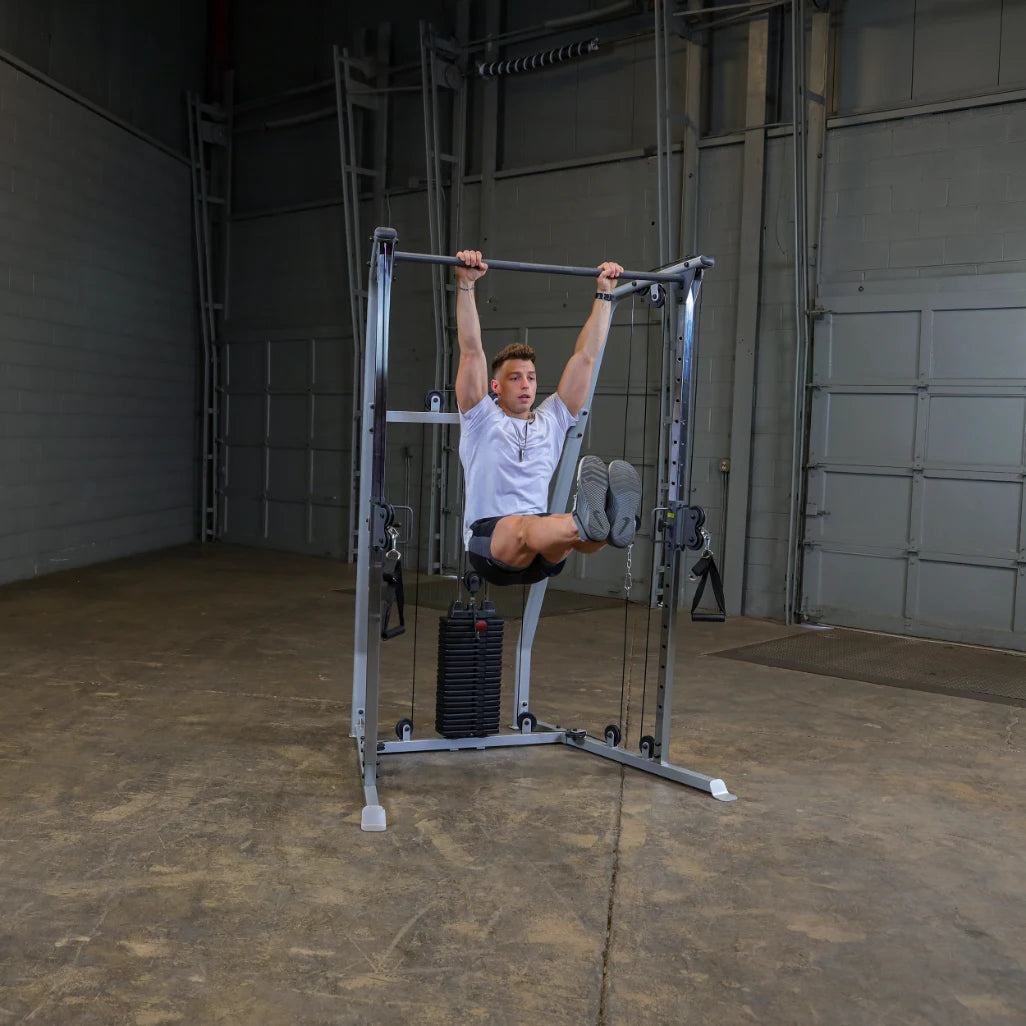 A young man performing a hanging leg raise exercise on a gym machine, showcasing strength training in an indoor fitness space.