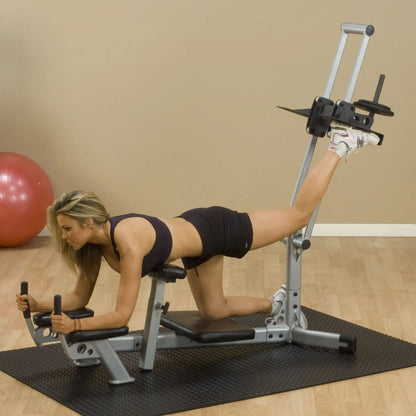 A woman performing a leg workout on a gym machine, focusing on her form and posture, with a stability ball in the background.