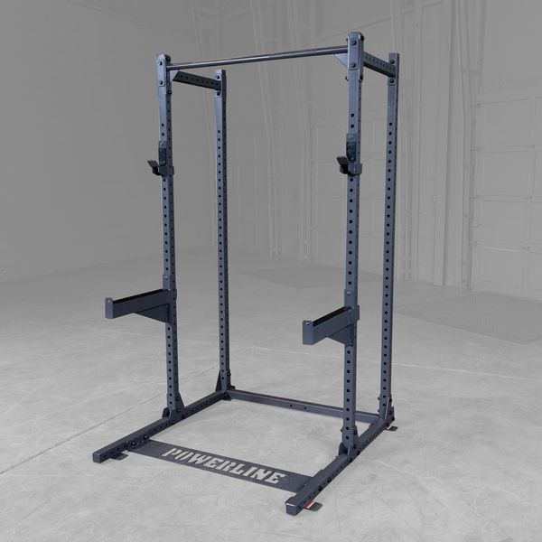 A black Powerline squat rack with adjustable pull-up bar and safety arms, set against a gray background in a gym or workout space.