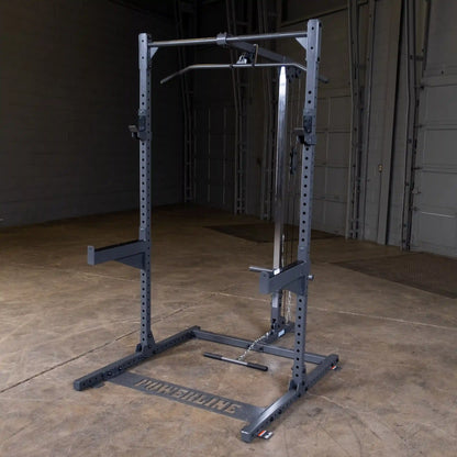 A Powerline weightlifting machine featuring a sturdy frame with adjustable pull-up and cable attachments, set in a spacious gym environment with a concrete floor and warehouse-style backdrop.