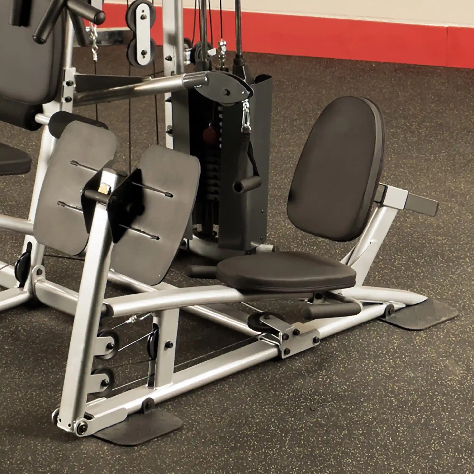 A close-up view of a gym exercise machine featuring adjustable seats and weight stacks, designed for strength training.
