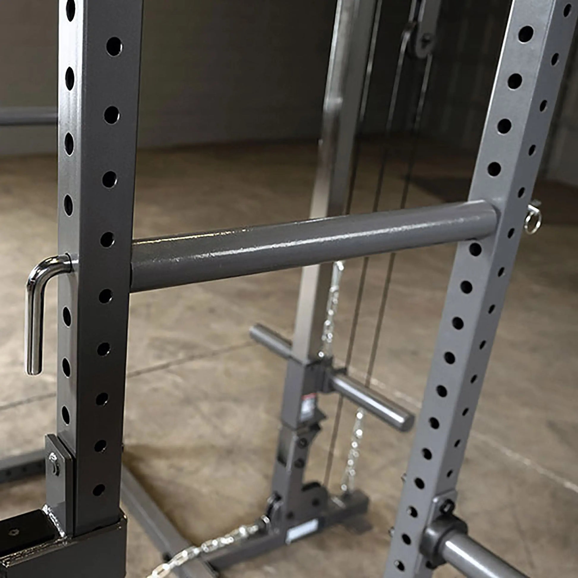 Close-up of a weightlifting rack with adjustable bars and a sturdy metal frame, featuring multiple holes for customization.