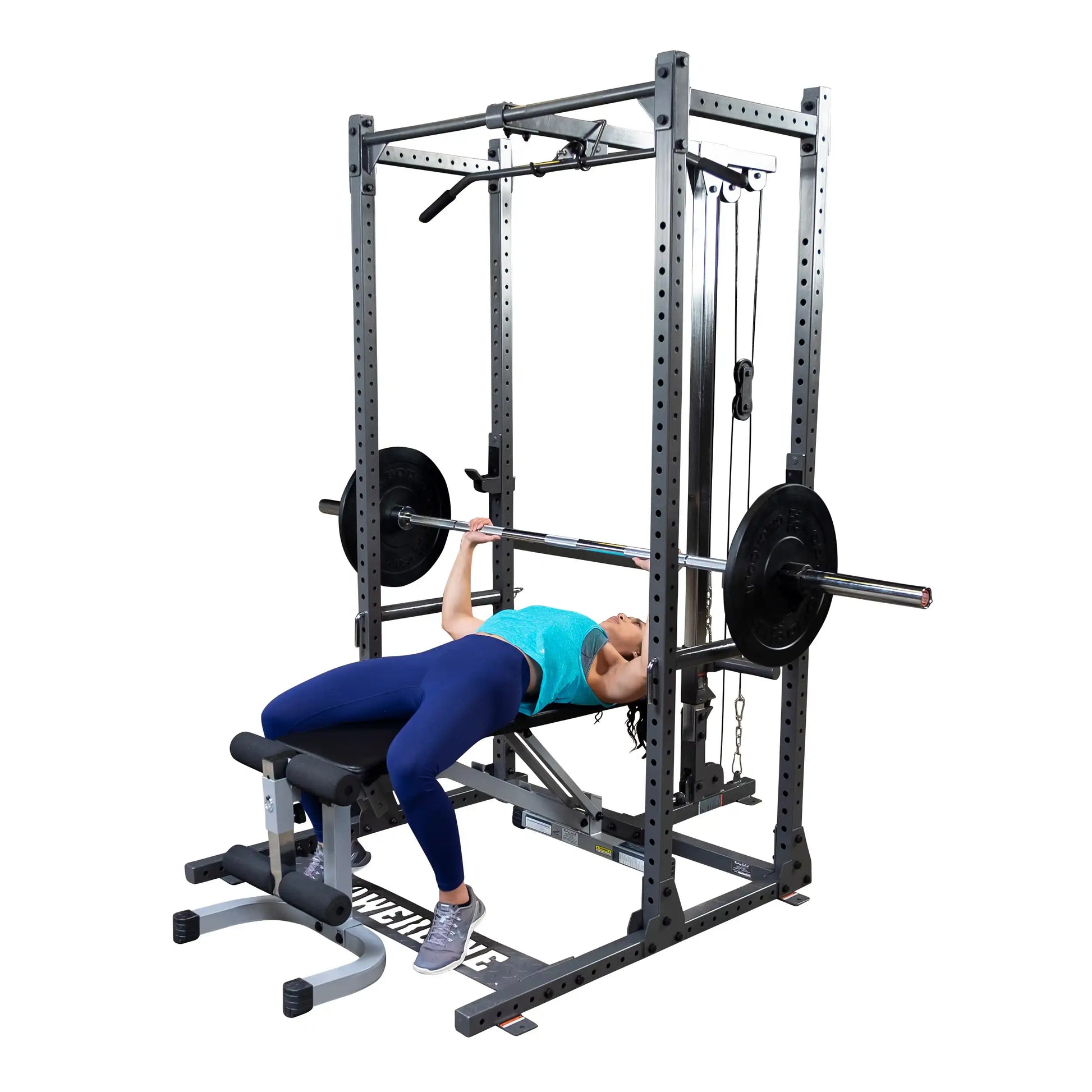 A person performing a bench press exercise on a weightlifting machine, wearing a blue tank top and leggings, with a barbell and weights positioned above them.