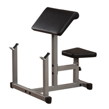 A black padded gym bench with a slanted backrest and a small seat, designed for strength training exercises, set on a sturdy metallic frame.