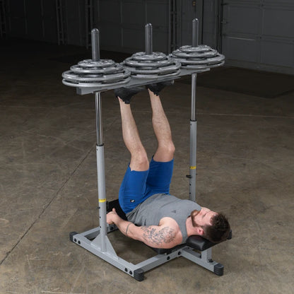 A man performing a leg exercise on a weight bench, lifting weights with his legs while lying on a padded bench in a gym setting.