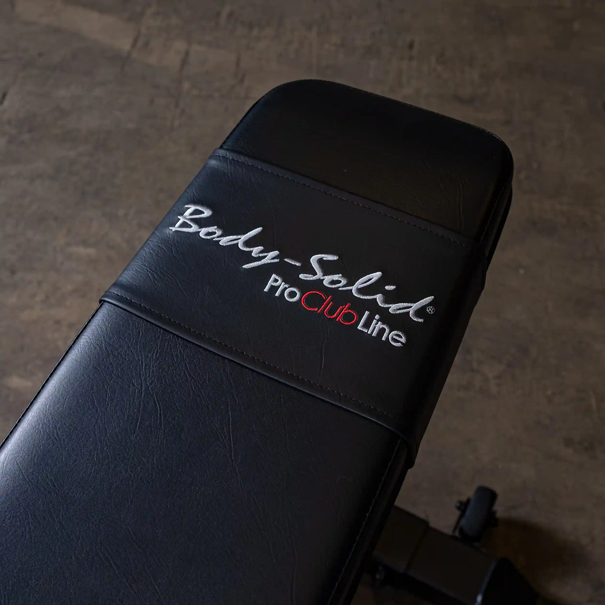 Close-up of the Body-Solid Pro ClubLine Adjustable Bench SFID325 showing the black padded surface with embroidered logo.