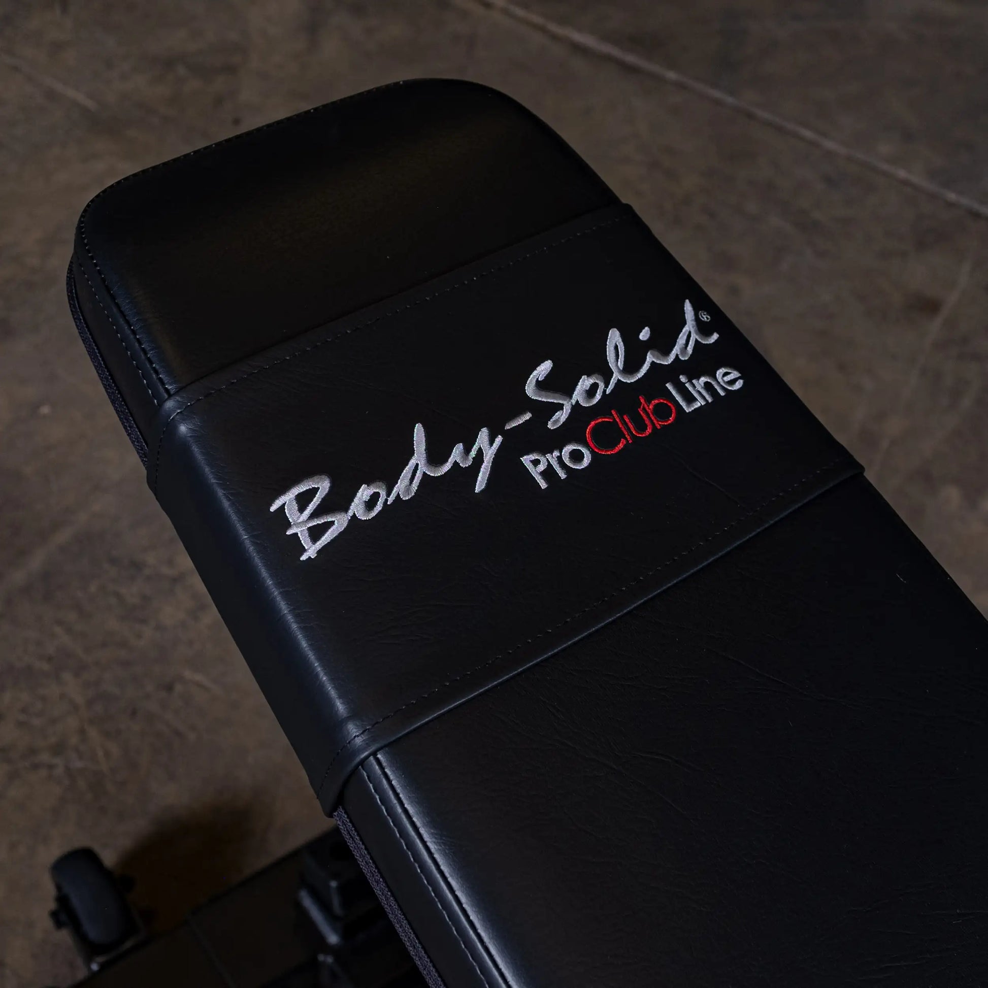 Close-up of the Body-Solid Pro ClubLine Adjustable Bench SFID325, featuring a black padded surface with embroidered branding.