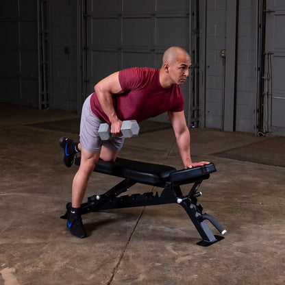 A person performing a dumbbell row exercise on a Body-Solid Pro ClubLine Adjustable Bench SFID325 in a gym setting.