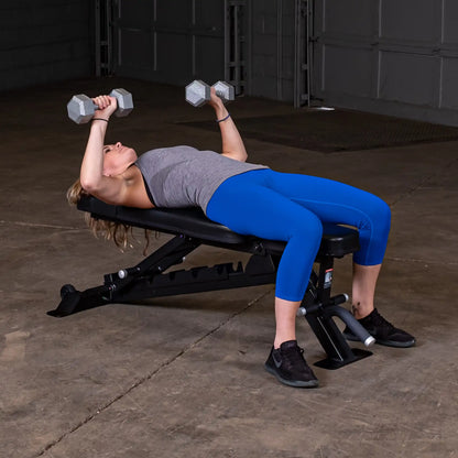 A person exercising on the Body-Solid Pro ClubLine Adjustable Bench SFID325, lying back while performing a dumbbell press with weights in hand.