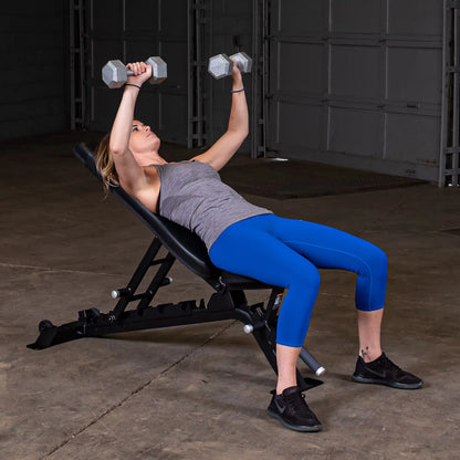 A woman performing an exercise with dumbbells on the Body-Solid Pro ClubLine Adjustable Bench SFID325 in a gym setting.